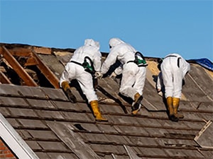 Three workers removing asbestos on college rooftop